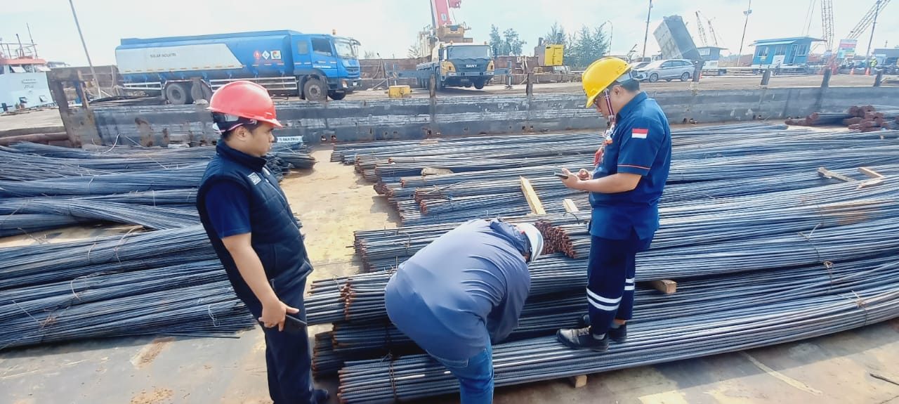 Tiga petugas memeriksa besi beton di area dermaga